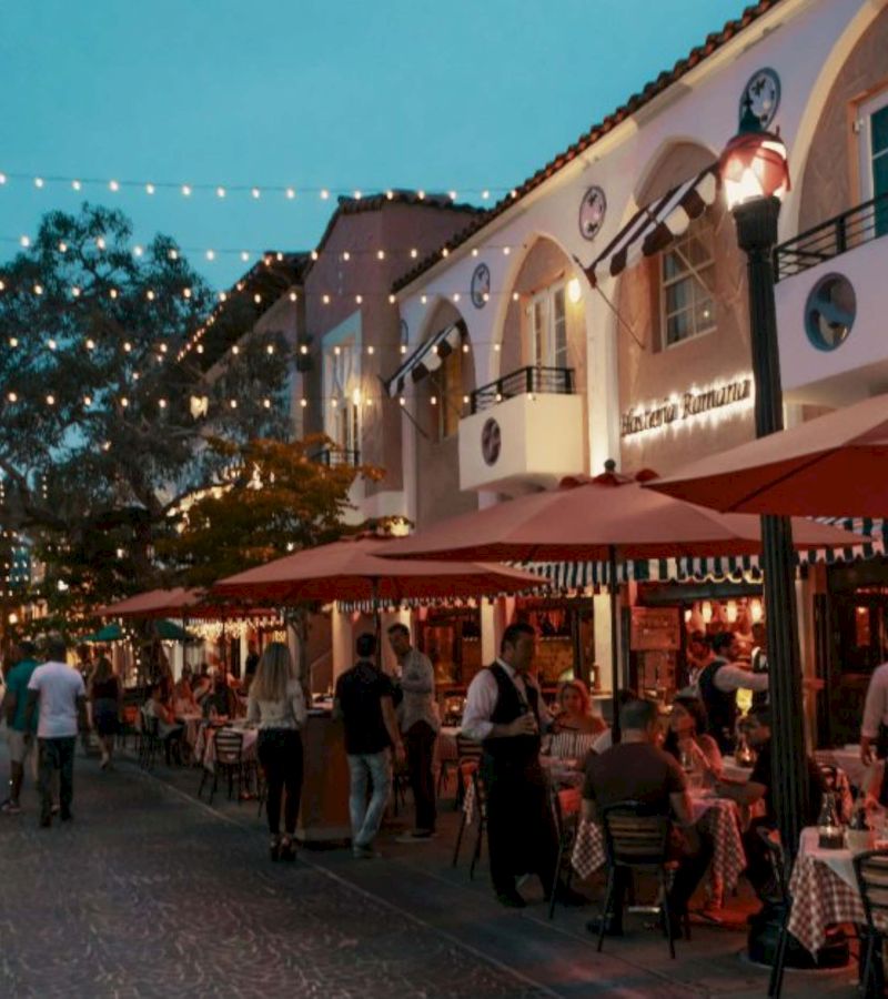 A restaurant exterior with outdoor seating at dusk.