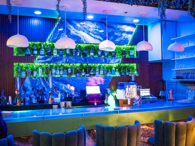 a dimly lit bar with a counter and stools